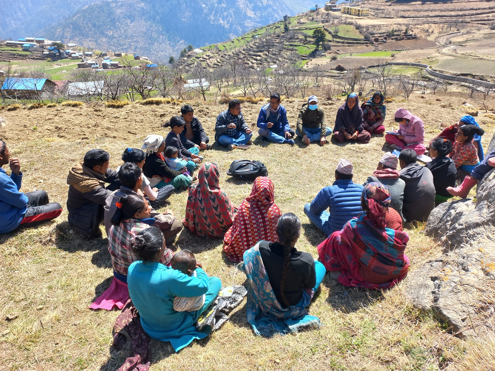 SDP community gathering: people in a circle on a terraced hillside in rural Nepal